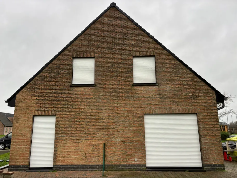 Bakstenen gevel met zwarte strepen en roet door luchtvervuiling