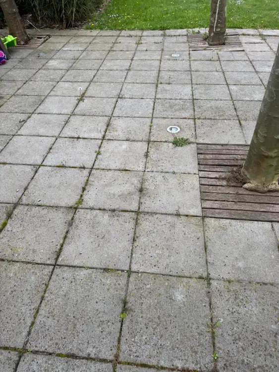 Verweerde betonnen bestrating met zichtbare slijtage en vervuiling