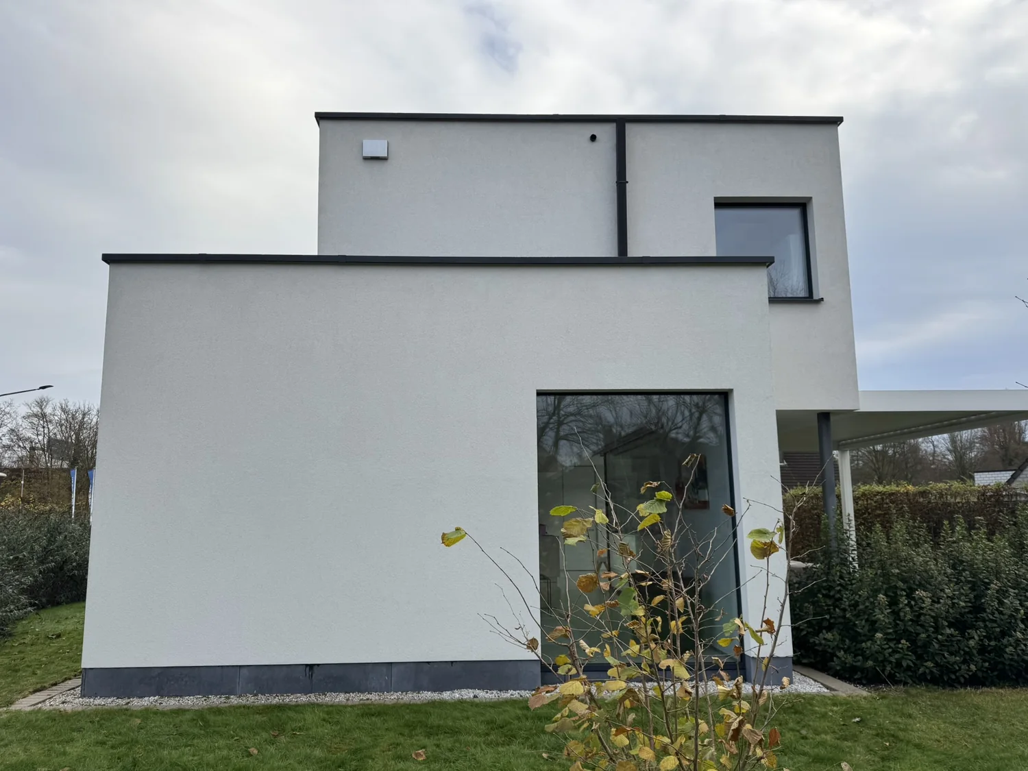 Dezelfde gevel na reiniging: het pleisterwerk is opnieuw egaal wit, met behoud van de crepistructuur.