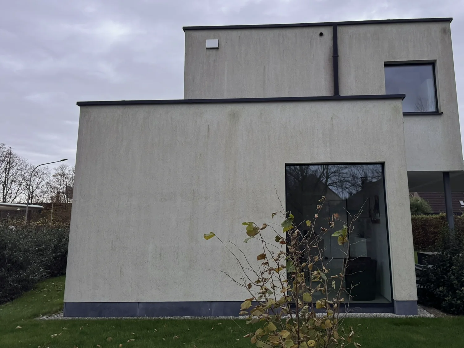 Woning waarvan de volledige crepigevel egaal grijsgroen is aangeslagen.