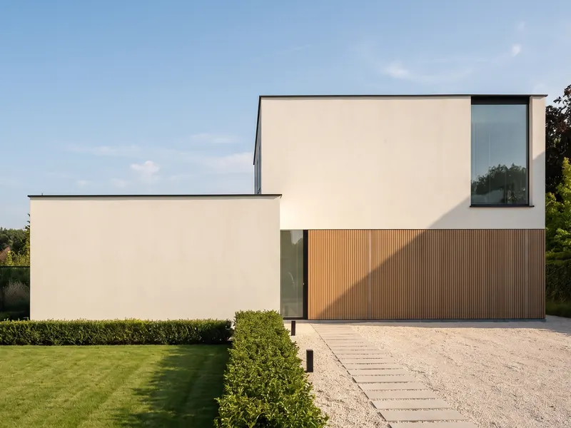 Moderne woning met een egale, lichte crepigevel op een zonnige dag.