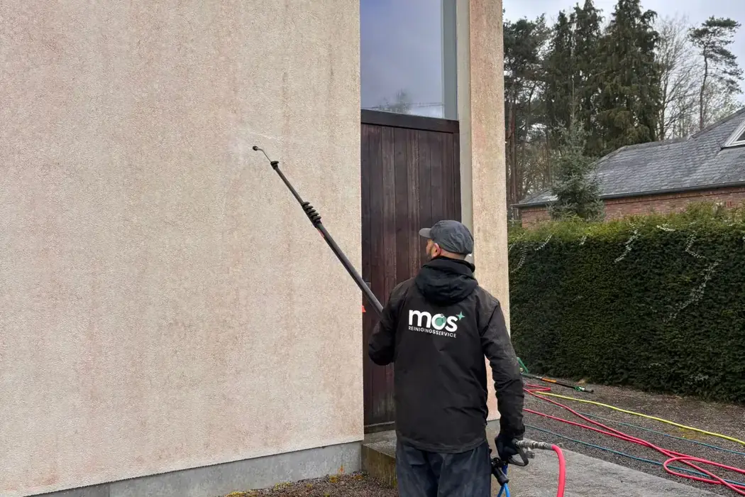 Medewerker van MOS Reinigingsservice reinigt een crepigevel met een telescooplans.