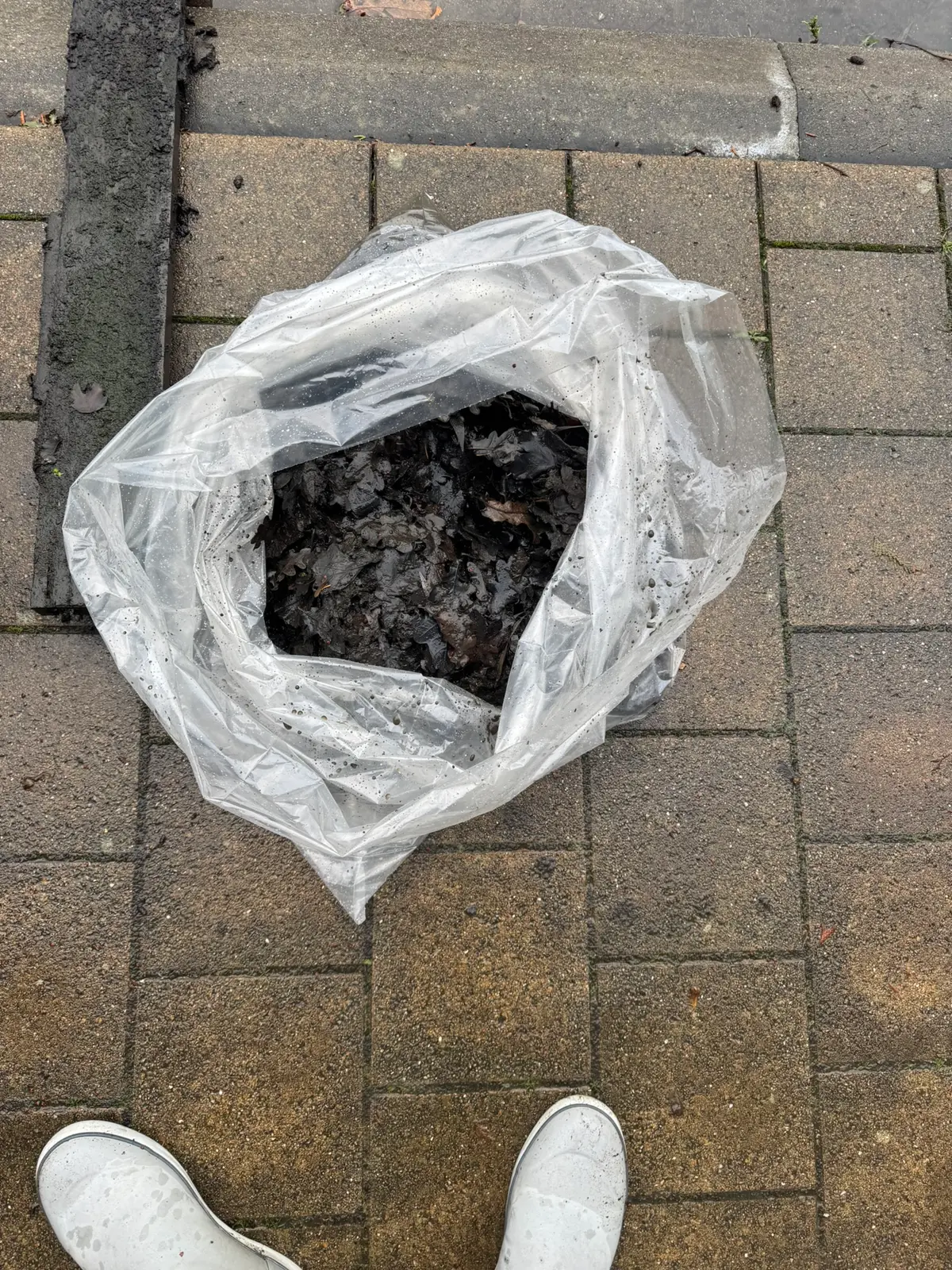 Zak met het vuil dat uit de goot is gehaald.