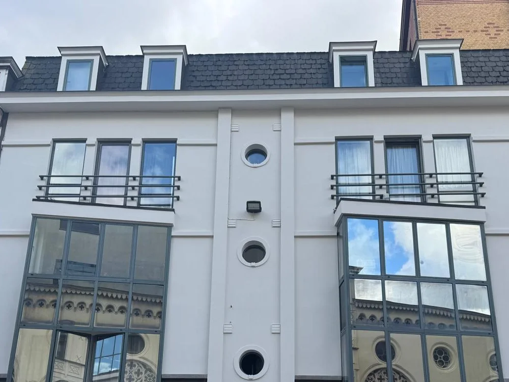 Crepi schilderen — dezelfde gevel na het schilderwerk in Gent, egaal wit.