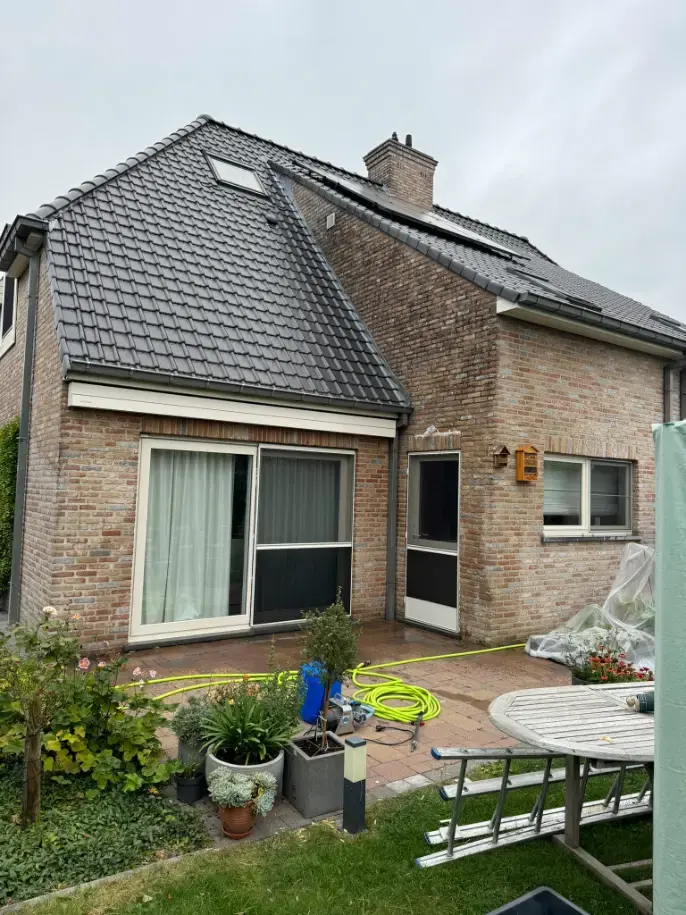 Bakstenen gevel Wondelgem voor de reiniging – zwarte aanslag zichtbaar