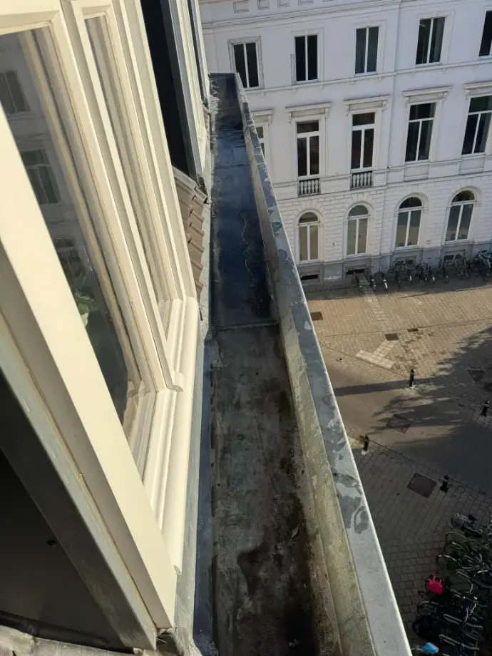 Dakgootreiniging in uitvoering bij woning in Gent
